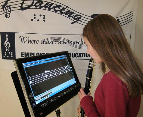 Image of girl holding clarinet standing in front of The Lime Lighter displaying magnified music notation.
Device is mounted on a Manhasset music stand